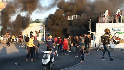 Iraqi Anti-government demonstrators block a road with debris and burning tires in the southern Iraqi city of Nasiriyah. AFP