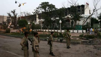 Pakistani policemen stand guard in front of the devastated Marriott Hotel in Islamabad on Sept 21 2008.