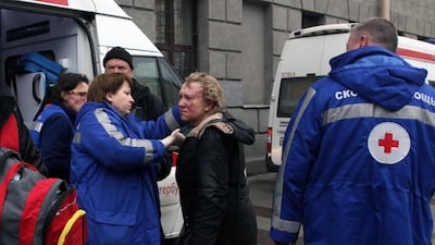 Medics help an injured woman outside the Technological Institute metro station in St Petersburg. Alexander Tarasenkov / AFP