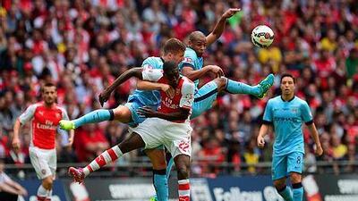 Arsenal's French striker Yaya Sanogo, centre, goes up for a high ball with Manchester City's Brazilian midfielder Fernando, right, and Manchester City's Serbian defender Aleksandar Kolarov during the FA Community Shield football match between Arsenal Manchester City at Wembley Stadium in north London on August 10, 2014. AFP PHOTO / CARL COURT