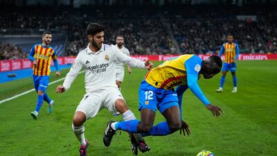Real Madrid's Marco Asensio, left, fights for the ball with Valencia's Mouctar Diakhaby. AP Photo