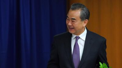 China's Foreign Minister Wang Yi signs a book during a meeting with the United Nations Secretary General. AFP