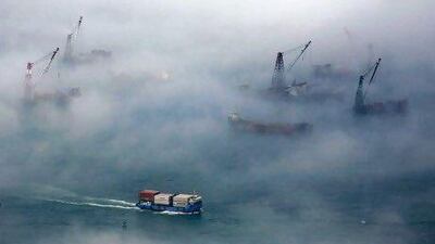 A container ship sails past barges during foggy conditions at Hong Kong's Victoria Harbour. Reuters