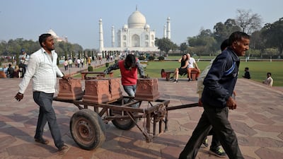 Workers move carved stones on a handcart inside the historic Taj Mahal premises, where U.S. President Donald Trump and first lady Melania Trump are scheduled to visit, in Agra, India. REUTERS