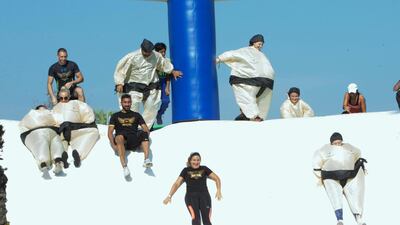 Residents tumble down an inflated slide during Dubai's inaugural inflatathon. Leslie Pableo for The National