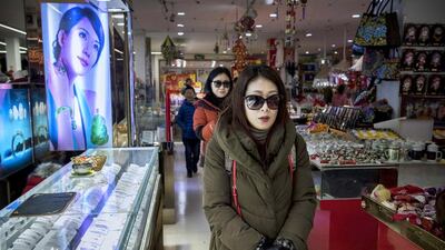 Chinese shoppers walk through a small department store in central Beijing. China’s economic growth has recently slowed to its weakest level in years to 7.4 per cent. Kevin Frayer / Getty Images