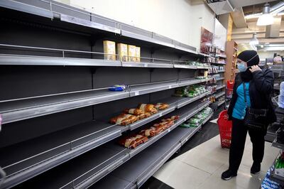 A customer walks past nearly empty shelves at a supermarket in Beirut amid shortages and high prices created by Lebanon's economic crisis. EPA