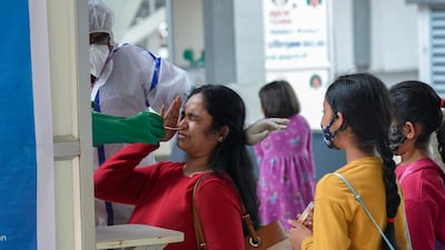 A health worker takes swab sample of a passenger arriving from the UK at Anna International Airport in Chennai. AFP