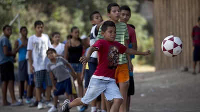 Maynor Ayala, 11, kicks the ball during soccer practice in his Progreso neighbourhood in Tegucigalpa, Honduras. His coach tells them that football will keep them out of trouble, and they agree that is what they want. Yet Maynor says it is harder to stay out of the gangs than to join. (AP Photo/Dario Lopez-Mills)