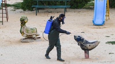 A health worker disinfects the Enahli amusement park at Ariana near Tunis, which has been closed to the public. AFP
