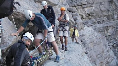 Members of the volunteer rescue team assisting Cameron Brooks, 43, after his 10 metre tumble in Wadi Ghalilah