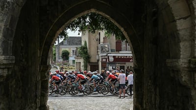 The riders cycle past an archway in a medieval tower in Mennetou-sur-Cher. AFP