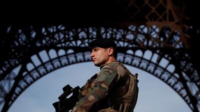 A French soldier stands guard under the Eiffel Tower. REUTERS/Christian Hartmann