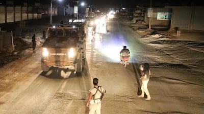 Syrian anti-regime fighters gather as a convoy of Turkish military vehicles heading toward the northern Syrian Idlib province drives on a road near the town of Atareb in Syria's northwestern Aleppo province. AFP