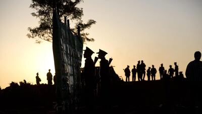 Ta’ang National Liberation army officers look at a noticeboard as others walk in a parade ground ahead of the 52nd Ta’ang revolution day celebrations in Mar-Wong, Ta’ang self-governing area, northern Shan state, Myanmar. Gemunu Amarasinghe / AP
