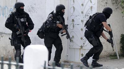 Tunisian anti-terrorism brigade personnel enter a house to take position after a shooting at the Bouchoucha military base in Tunis on May 25. Reuters