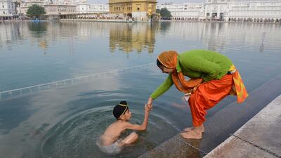 An Indian Sikh devotee bathes in the holy sarovar on the occasion of martyrdom day of Guru Tegh Bahadur at the Golden Temple in Amritsar. Narinder Nanu / AFP