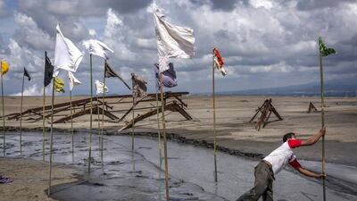 A man sets up an art installation by artist Dadang Christanto, with title 'Gombal' or 'Rags' at the mudflow during the tenth anniversary of the eruption Ulet Ifansasti / Getty Images