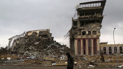 A student walks past damaged buildings at the University of Mosul in 2017. AP