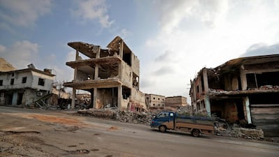 A truck rides past destroyed buildings in the town of Ihsim in the southern countryside of Idlib. AFP