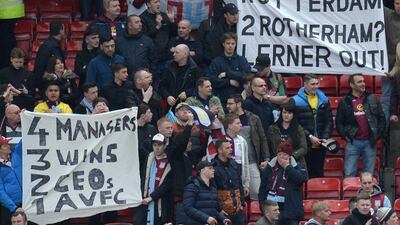 Aston Villa fans hold up banners (R) referencing their 1982 European Cup victory in Rotterdam and their relegation to the Championship where Rotherham currently sit at 21st in the table during the Premier League football match between Manchester United and Aston Villa at Old Trafford in Manchester, north west England, on April 16, 2016. AFP / OLI SCARFF