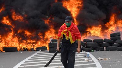A man walks past burning tyres at the barricade. AFP