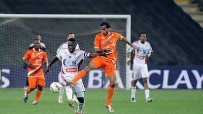 Al Jazira's Ibrahim Diaky, left, tries to shield the ball against Ajman's Jasem Al Mohammed.