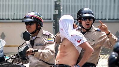Members of the national police arrest a man during a protest against Venenzuelan President Nicolas Maduro in Caracas. Carlos Becerra / AFP