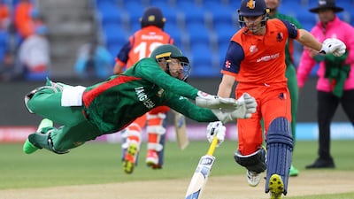 Bangladesh's Nurul Hasan dives to field the ball as Netherlands' Colin Ackermann run through. AFP
