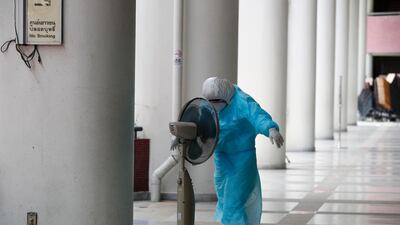 A health worker wearing a full protective suit cools down with an electric fan during a free Covid-19 test for at-risk people amid the coronavirus pandemic in Bangkok, Thailand. EPA