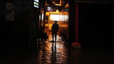 A pedestrian walks through a flooded street at Dashashwamedh Ghat in Varanasi. Sanjay Kanojia / AFP