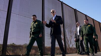 Mr Biden walks along the border fence during his visit to the US-Mexico border. Reuters