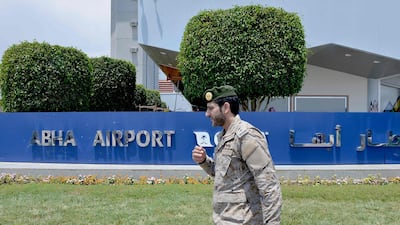 A Saudi serviceman walks by a sign outside Abha airport. AFP