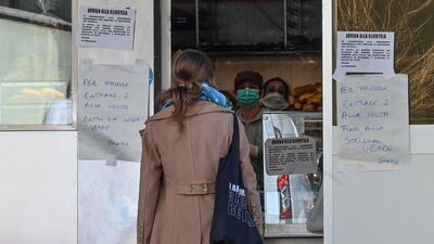 A resident waits in line to buy bread at a bakery in Rome's Monteverde Vecchio district. AFP