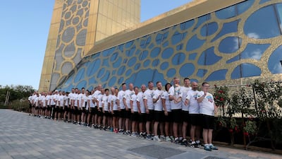 Volunteers, staff members and athletes holding the Special Olympics torch “Flame of Hope” at the Dubai Frame in Zabeel Park. Pawan Singh / The National