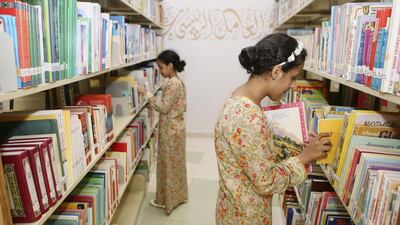 Sadaa Saleh, 10, and her older sister, Hasna Saleh, 13, browse through the titles at Al Bahia Park Library in Abu Dhabi. Sarah Dea / The National