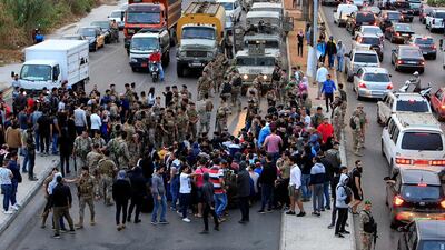 Demonstrators trying to block a road gather in front of soldiers during ongoing anti-government protests in Sidon, Lebanon. Reuters