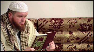This image provided by New Zealand 3 News/MediaWorks via APTN shows Mark Taylor, who converted to Islam and joined ISIS in Syria, as he reads the Quran in his native New Zealand. APTN
