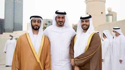 Sheikh Zayed bin Mansour bin Zayed (L) and Sheikh Hazza bin Hamdan bin Zayed (R) pose for a photograph with Sheikh Mohamed bin Sultan bin Khalifa (C) during the group wedding at Qasr Al Hosn.