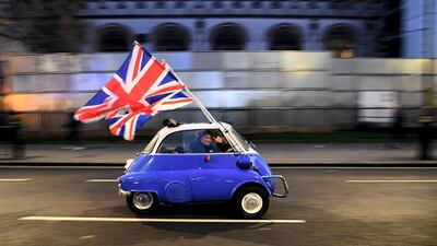 A man waves flags as he drives past Brexit supporters gathering in Parliament Square, in central London, on the day that the UK formally left the European Union - January 31, 2020. AFP