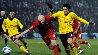 Leyton Orient's Andrew Whing, left, fights for the ball with Arsenal's Tomas Rosicky.