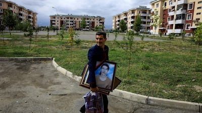 Iman Abisiv carries his belongings from his damaged home after a ceasefire begins during the fighting over the breakaway region of Nagorno-Karabakh in the city of Terter, Azerbaijan. Reuters