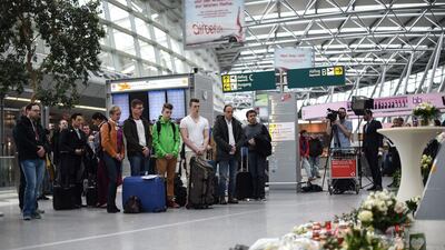 Visitors and travelers stand in a moment of silence on March 26, 2015 at a memorial desk set up in commemoration of the victims of the Germanwings plane crash at the airport in Duesseldorf where the jet was due to land. Maja Hitij/EPA