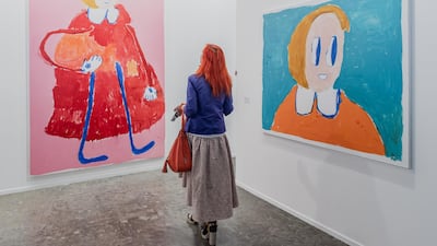 A visitor with the works of Andre Butzer, shown at Carbon 12's booth during Art Dubai 2019. Photo Solutions