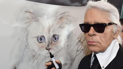 Karl Lagerfeld poses next to a painting of his cat, Choupette. AFP