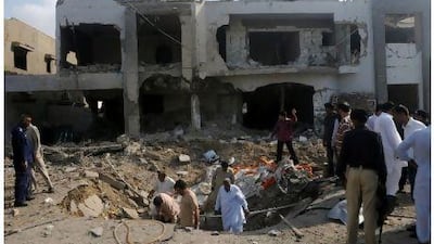 Pakistani investigators inspect the crater caused by a bomb blast in Karachi yesterday when eight people were killed and several more wounded in a car bomb attack targeting a senior policeman. Rizwan Tabassum / AFP Photo