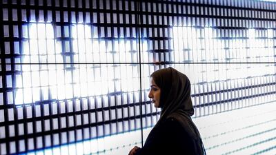A woman pictured against the a display reading 'Abu Dhabi' at a booth during the Fintech Festival in Singapore. Wallace Woon / EPA