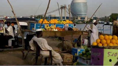 The Burj al-Fateh hotel dominates the skyline across the Nile from a local market.
