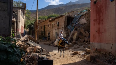 A boy rides a pony past the rubble of a collapsed building in Tnirte. Getty Images