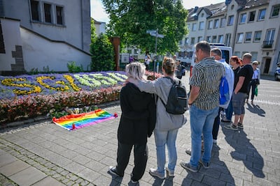 People in mourning stand close to the site of yesterday's deadly stabbings that left three dead and eight injured in Solingen, Germany. Getty Images